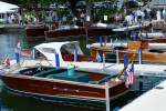 Multiple antique boats docked on a summer day